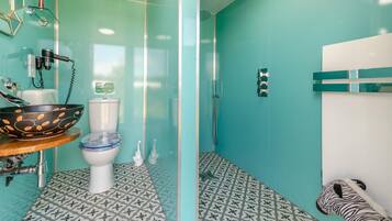 Un bagno con un water, un lavandino, una doccia e una decorazione a tema zebrato.