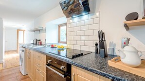 Una cocina moderna con encimera de granito, electrodomésticos de acero inoxidable y horno empotrado.