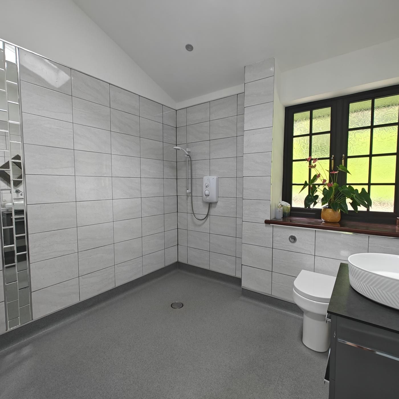 Un baño moderno con ducha, inodoro y lavamanos.