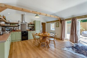 A kitchen with wooden beams, a dining table with chairs, and a view of the outdoors. - 2 Bed in Hartest (oc-w42830) (Hartest)