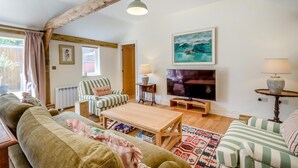 A cozy living room with a wooden ceiling, a television, a striped sofa, and a coffee table. - 2 Bed in Hartest (oc-w42830) (Hartest)