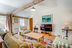 A cozy living room with a wooden ceiling, a television, a striped sofa, and a coffee table. - 2 Bed in Hartest (oc-w42830) (Hartest)