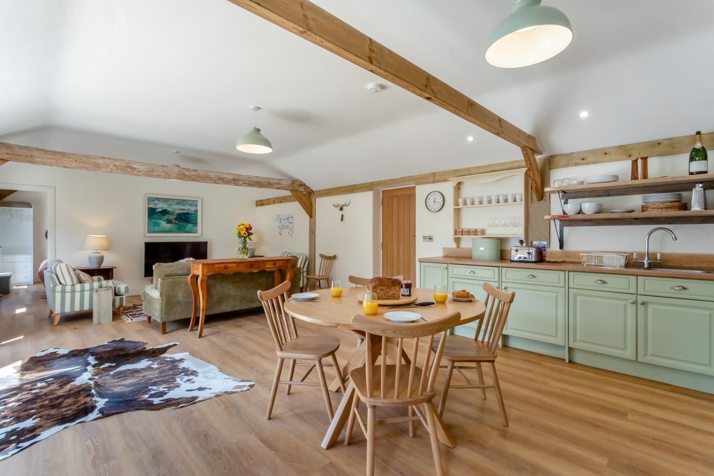 A cozy dining area with wooden furniture, a central table, and a rustic ceiling.