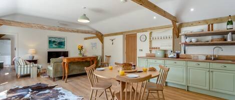 A cozy dining area with wooden furniture, a central table, and a rustic ceiling.