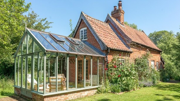 A traditional brick house with a conservatory, a garden, and a clear blue sky. - 2 Bed in Sibton (oc-q43760) (Sibton)