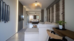 Una sala de estar moderna con sofá, mesa de comedor y televisor.