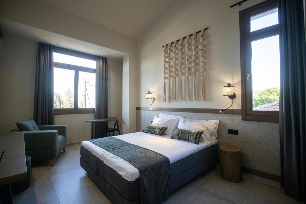 Une chambre à coucher avec un lit, un bureau, une chaise et une petite table.