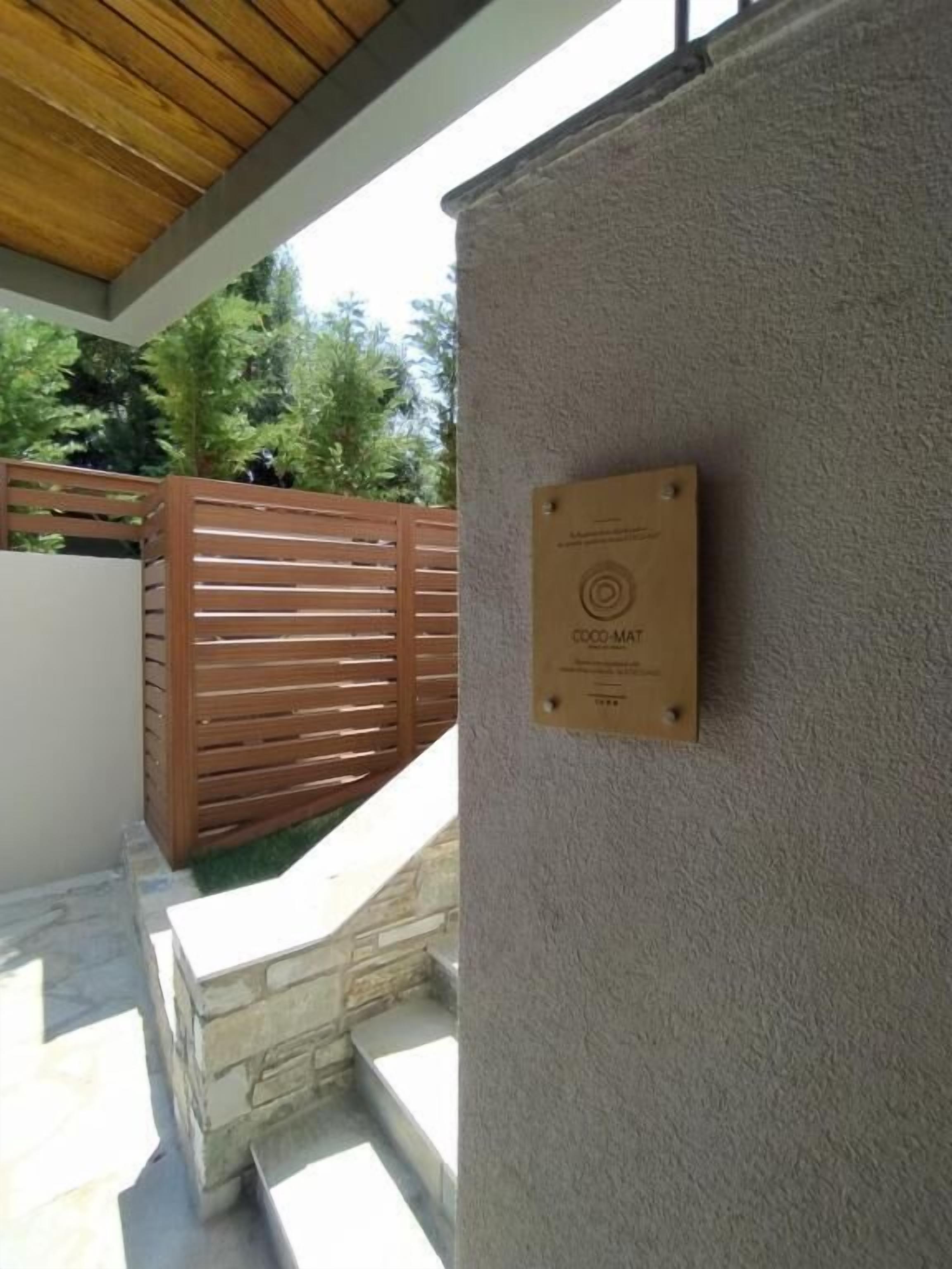 Una placa en una pared, una valla de madera y una escalera de piedra.