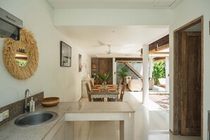 Eine Küche mit Granit Arbeitsplatte, Spüle aus Edelstahl und einem Essbereich mit Holztisch und Stühlen.