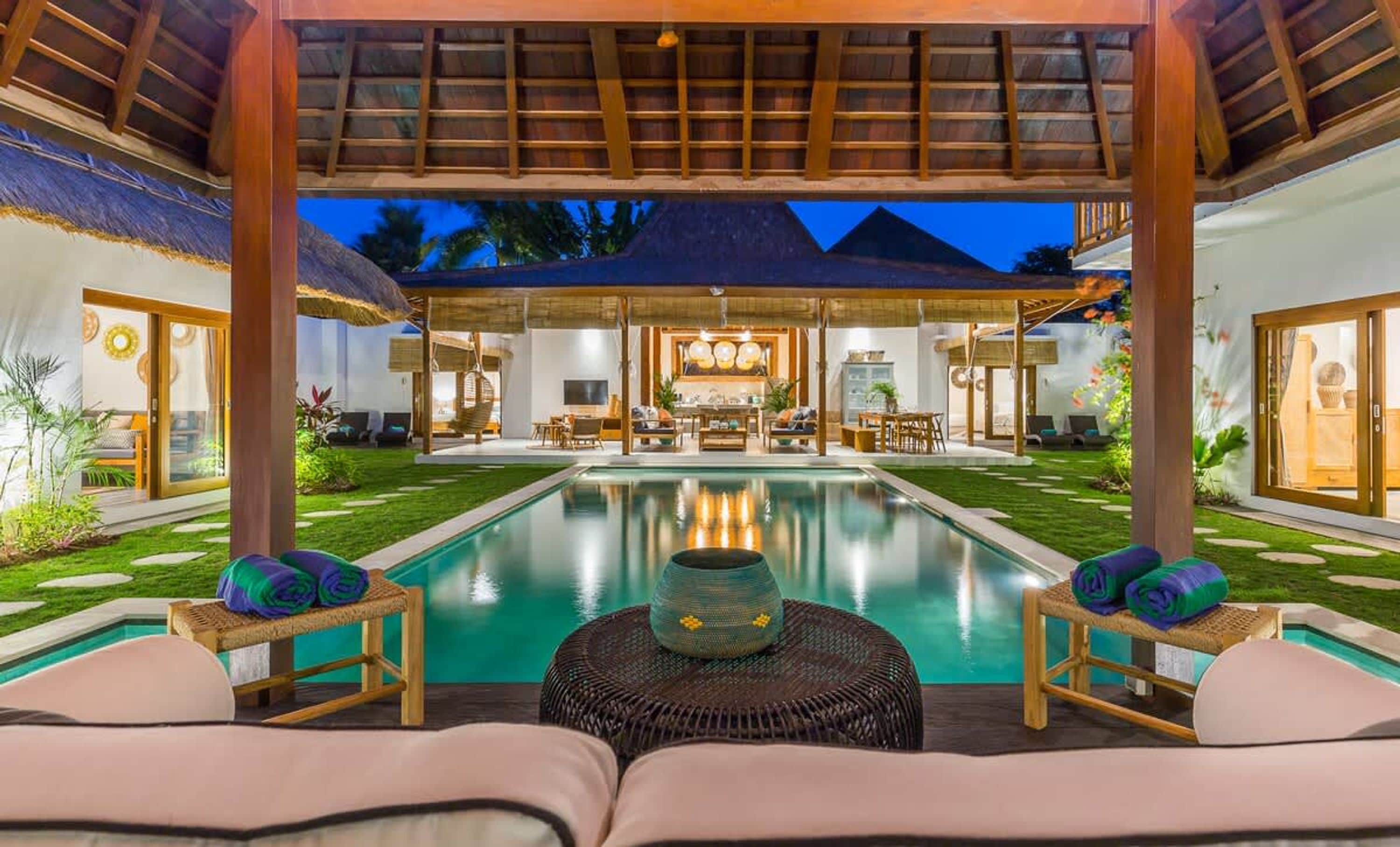 A poolside area with a covered seating area, a dining space, and a view of a pyramid.