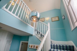 A staircase with white railings and a hanging light fixture. - 3 Bed in Beaumaris (oc-h44704) (Beaumaris)