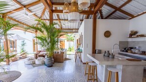 Una cocina amplia con una isla central, taburetes de bar y un comedor con vistas.