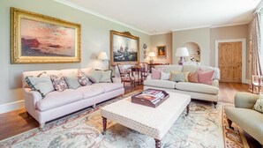 Ein Wohnzimmer mit zwei Sofas, einem Couchtisch und einem Essbereich mit Stühlen.