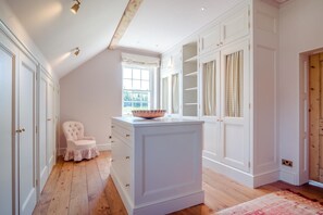 A room with a wooden floor, white cabinetry, a window with curtains, and a chair. - 6 Bed in Chebbard (oc-c43267) (Puddletown)