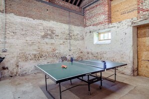A ping pong table in a room with exposed brick walls and a window. - 6 Bed in Chebbard (oc-c43267) (Puddletown)
