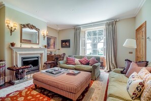 A living room with a fireplace, a sofa, a coffee table, and a window with curtains. - 6 Bed in Chebbard (oc-c43267) (Puddletown)