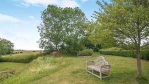 A grassy outdoor area with a wooden bench and trees. - 4 Bed in Chebbard (oc-c43270) (Puddletown)