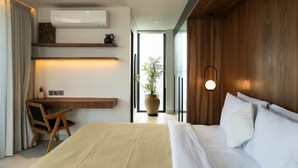 Una habitación de hotel moderna con cama, escritorio, silla y un ventanal grande.