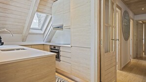 A modern kitchen with wooden cabinetry, a built-in oven, and a skylight. - Luderna - Dúplex Val de Ruda C37 Malh Blanc (Baqueira)
