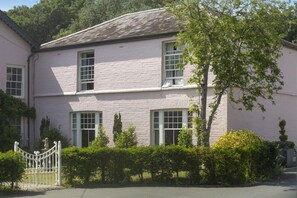 A two-story building with a symmetrical facade, multiple windows, and a gated entrance. - 2 Bed in Beaumaris (oc-l44702) (Beaumaris)
