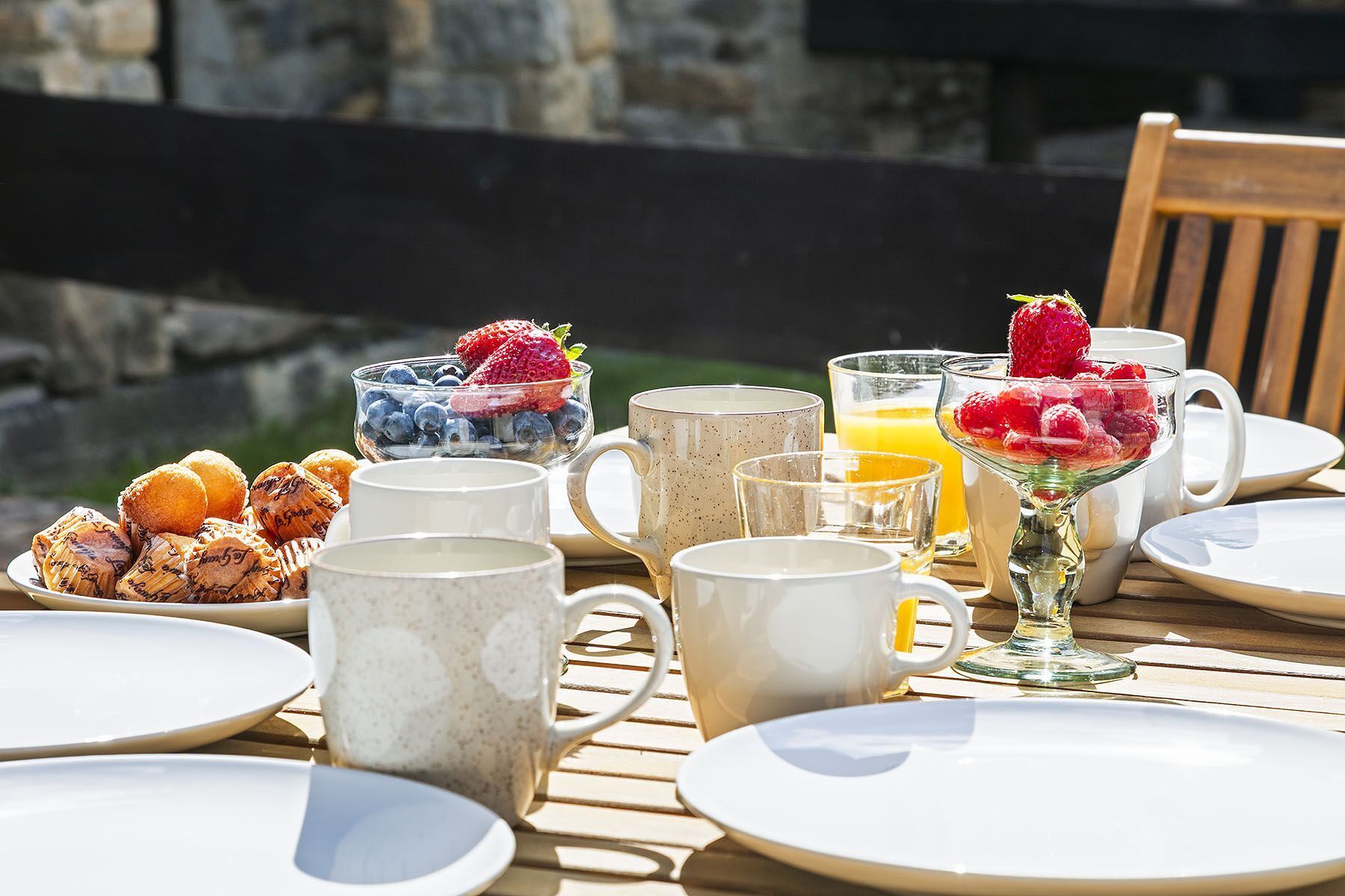 Desayuno con diversos alimentos y bebidas sobre una mesa de madera.
