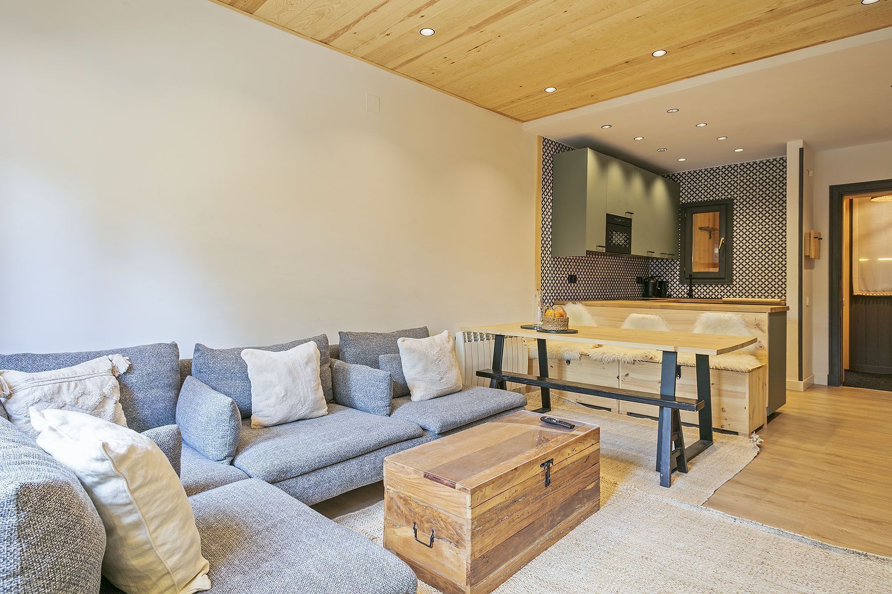 A modern living room with a sofa, coffee table, and a wooden chest.