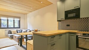 Eine moderne Küche mit Holzarbeitsplatte, eingebauten Schränken und einer gemusterten Spritzschutzwand.