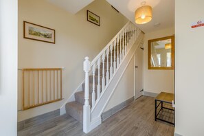 A staircase with white balusters, a wooden handrail, and a light fixture above. - 3 Bed in Mundesley (oc-s44224) (Mundesley)