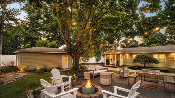 Un'area patio con poltrone Adirondack, un braciere e un tavolo.