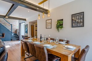 A dining area with a wooden table set for six, surrounded by leather chairs. - 4 Bed in Skirlaugh (oc-w43303) (Skirlaugh)