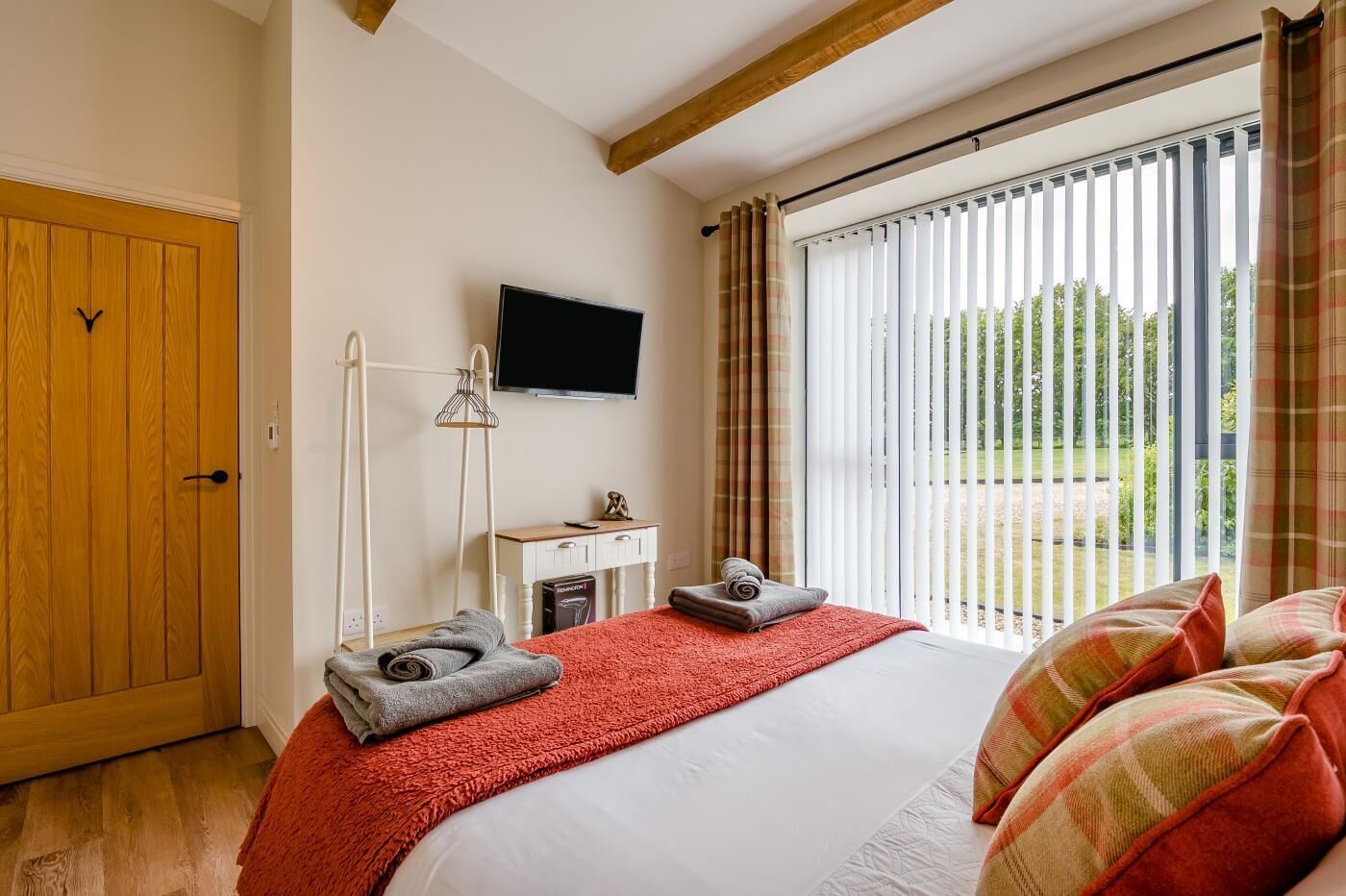 Ein Hotelzimmer mit einem Bett, einem Schreibtisch, einem Fernseher und Blick ins Freie.
