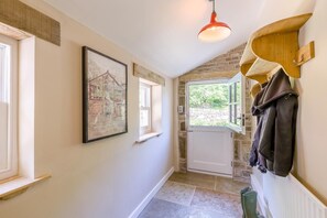 A hallway with a door, a coat rack, and a framed picture on the wall. - 2 Bed in Glossop (oc-h43766) (Glossop)