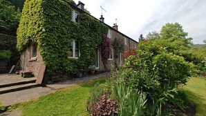 A stone house with ivy-covered walls, a stone staircase, and a well-maintained garden. - 3 Bed in Whatstandwell (oc-h42743) (Whatstandwell)