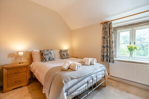 A bedroom with a bed, bedside table, lamp, and window with curtains. - 3 Bed in Whatstandwell (oc-h42743) (Whatstandwell)