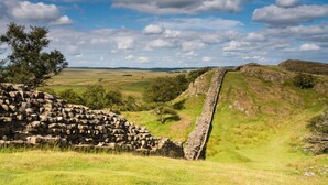 A stone wall leading to a stone structure in a grassy field with a clear sky. - 3 Bed in Carlisle (oc-a42763) (Carlisle)