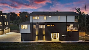 Een modern woongebouw met twee verdiepingen, een plat dak, grote ramen en een balkon.