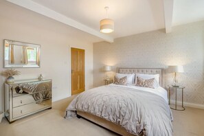 A bedroom with a bed, a dresser, a mirror, a door, and two bedside lamps. - 3 Bed in Scalby (oc-s42779) (Scalby)
