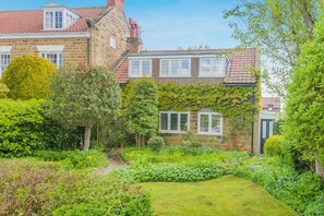 A stone building with a garden, a pathway, and a small lawn. - 3 Bed in Scalby (oc-s42779) (Scalby)