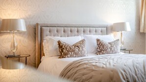 A neatly made bed with a tufted headboard, two bedside lamps, and patterned pillows. - 3 Bed in Scalby (oc-s42779) (Scalby)