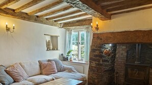 Une pièce chaleureuse avec une cheminée en pierre, un canapé en bois et une table basse assortie, également en bois.