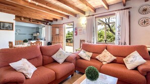 Una sala acogedora con dos sofás, una mesa de centro y vistas a la cocina y al exterior.