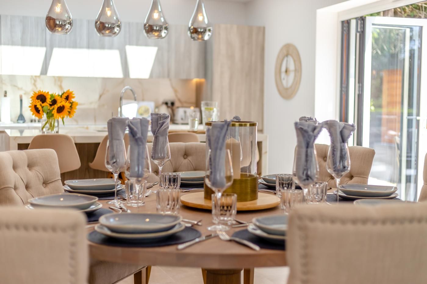 A dining area with a table set for a meal, including plates, glasses, and napkins.