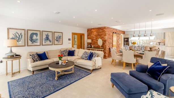 A modern living room with a sofa, coffee table, and blue patterned rug. - 4 Bed in New Milton (oc-b44761) (New Milton)