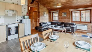 Ein gemütliches Blockhaus-Interieur mit Küche, Essbereich und Wohnzimmer.