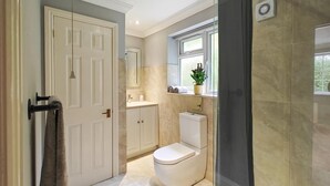 A bathroom with a toilet, sink, and mirror. - 1 Bed in Winterborne Zelston (oc-r43274) (Winterborne Zelston)