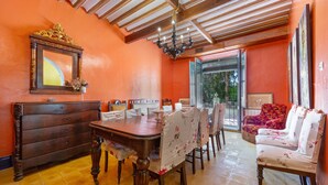 A dining area with a wooden table and chairs, a sofa, and a chandelier. - Country House 'La Florida' with Shared Pool, Wi-Fi and Air Conditioning (Los Menas)