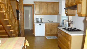 A kitchen with wooden cabinets, a microwave, a sink, a stove, and a refrigerator.