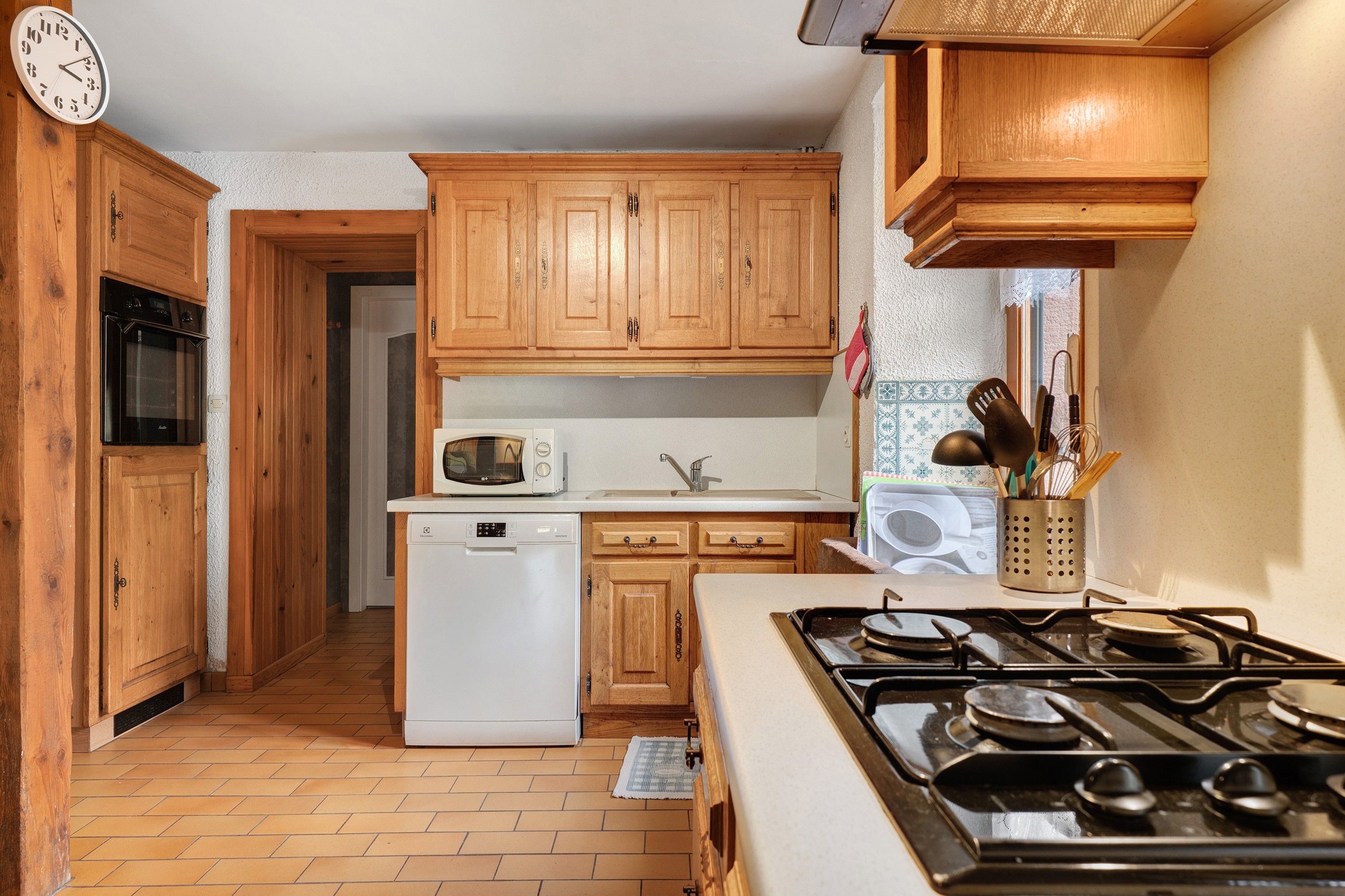 A kitchen with wooden cabinets, a microwave, a dishwasher, and a stove.