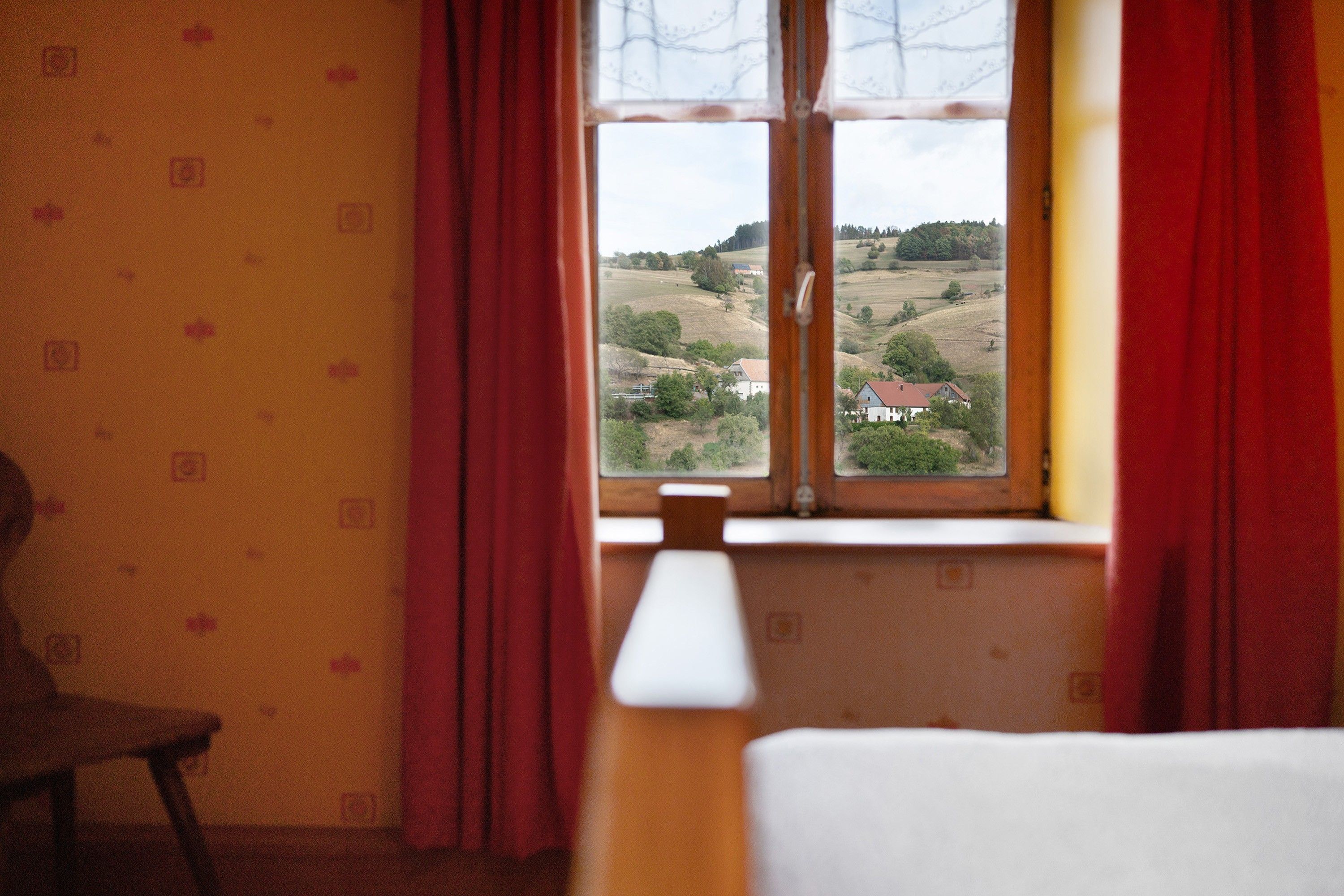 Une pièce avec une fenêtre, une chaise et une lampe.