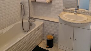 A bathroom with a bathtub, a sink, a window, and a towel rack. - Just a short walk from Avignon's historic center, a quiet apartment, (Avignon)